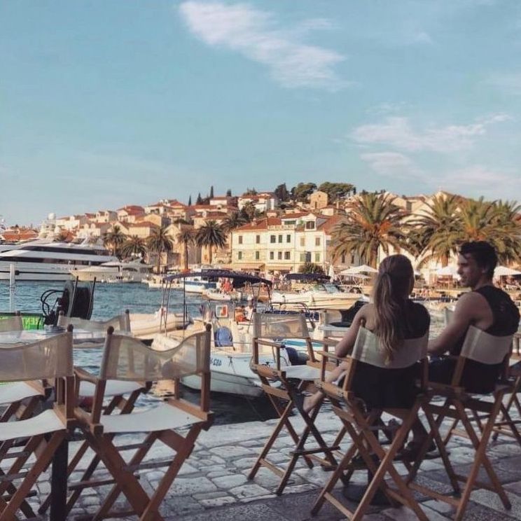 Café en terrasse face au port d'une ville méditerranéenne