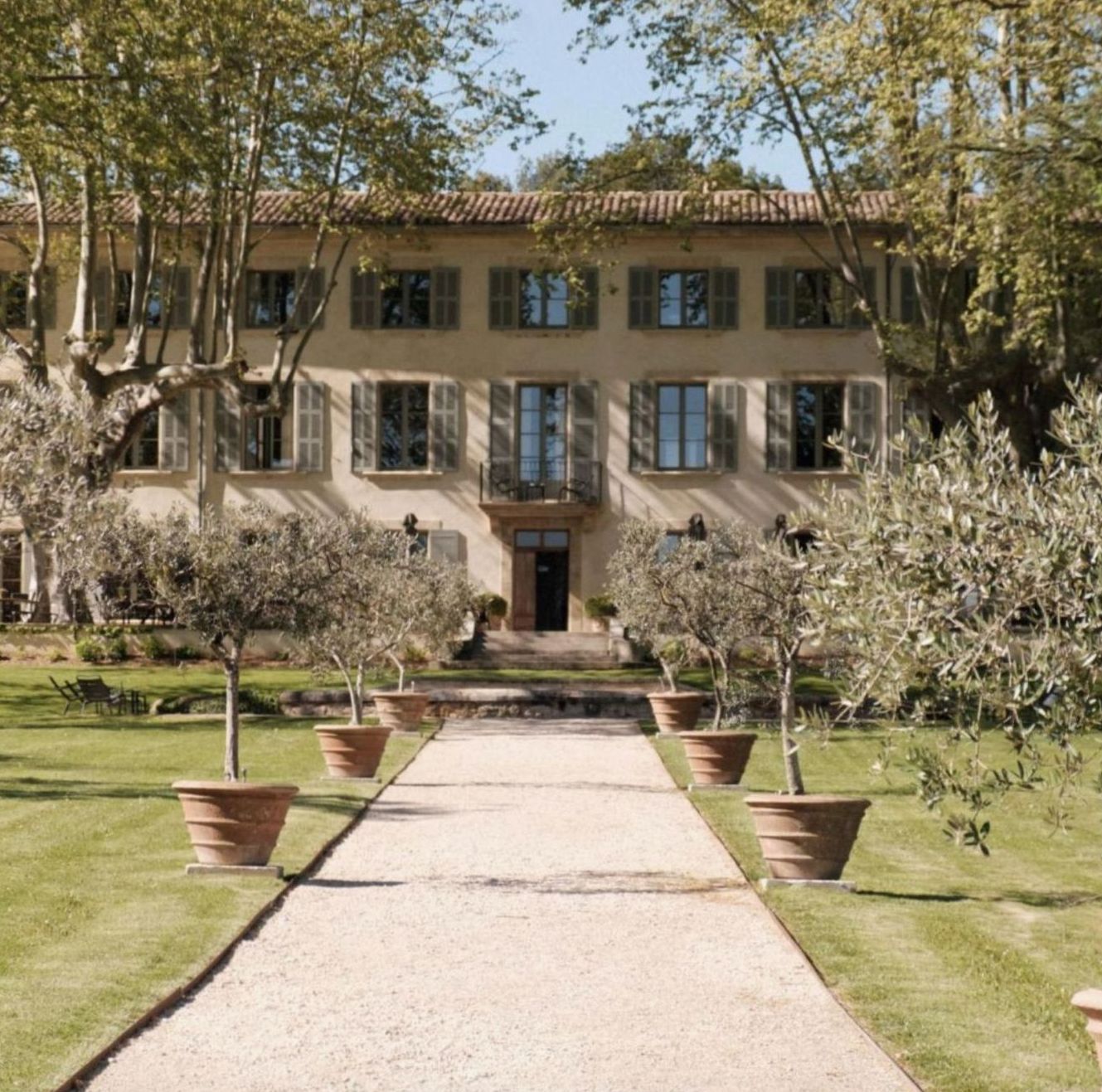 Façade d'un grand hôtel de charme entourée d'oliviers et de platanes