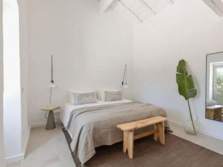 Chambre d'hôtel lumineuse aux tons blancs et lin