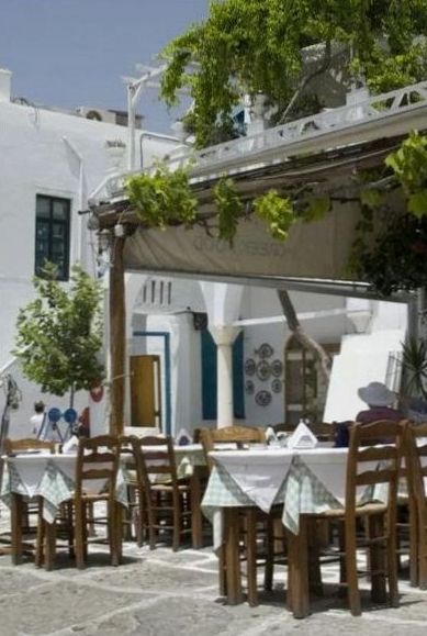 Terrasse d'une taverne grecque ombragée par la treille